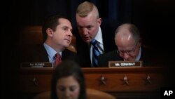 FILE - House Intelligence Committee Chairman Rep. Devin Nunes, R-Calif., left, speaks to an aide on Capitol Hill in Washington.