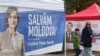 People walk past campaign tents of Moldova's incumbent President and presidential candidate Maia Sandu and presidential candidate Alexandr Stoianoglo in Chisinau, Moldova Oct. 30, 2024.