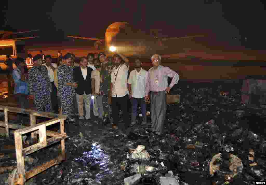 The governor of Sindh province, Ishrat ul Ebad, and security officials visit a damaged area after Sunday's attack on Jinnah International Airport in Karachi, Pakistan, June 9, 2014.