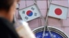 Bendera Jepang dan Korea Selatan terlihat di sebuah toko di daerah Shin Okubo di Tokyo. Jepang akan mengembalikan Korea Selatan ke daftar mitra-mitra dagang terpercaya pada bulan Juli. (Foto: AP)