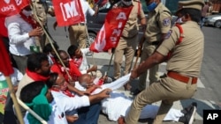 Policemen detain activists of various organizations as they block a highway during a nationwide shutdown called by thousands of Indian farmers protesting new agriculture laws in Hyderabad, India, Feb. 6, 2021.