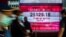 Pedestrians walk past an electronic sign displaying the Hang Seng Index in Hong Kong, March 9, 2020. Hong Kong stocks ended Monday's morning session sharply lower, in line with a rout across Asia, on coronavirus fears.