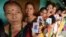 Indian voters pose for a photograph with their identity cards as they queue to cast their ballots in the state assembly elections at a polling station in Diphu in the Karbi Anglong district some 215 kms from Guwahati on April 4, 2016. 