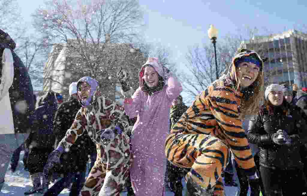 Young ladies wear animal onesie pajamas during an organized snowball fight at Dupont Circle in Washington, D.C., Jan. 24, 2016.