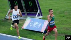 El mexicano Víctor Zambrano, a la derecha, compite en la final masculina de atletismo de 10.000 metros en los Juegos Centroamericanos y del Caribe en San Salvador, El Salvador, el viernes 7 de julio de 2023. (Foto AP/Arnulfo Franco)