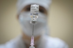 FILE - A nurse prepares a dose of the Sputnik COVID-19 vaccine for a patient at a clinic in Moscow, Russia, Dec. 30, 2020.