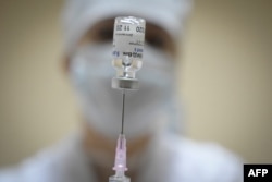 FILE - A nurse prepares a dose of the Sputnik COVID-19 vaccine for a patient at a clinic in Moscow, Russia, Dec. 30, 2020.
