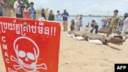 FILE PHOTO - Journalists take photographs of a bomb pulled from the murky depths of the Mekong River, Phnom Penh, Cambodia. 