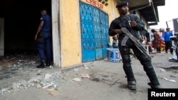 Des policiers déployés devant un magasin à Kinshasa, RDC, 23 janvier 2015.