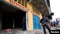 Un policier garde un entrépot lors des manifestations violentes à Kinshasa le 23 janvier 2015.