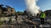 Fotografija koju je snimila i objavila Nacionalna policija Ukrajine 10. maja 2024. prikazuje zaposlenike Državne službe za vanredne situacije kako gase požare u privatnim kućama uništenim granatiranjem u Harkovu, u istočnoj Ukrajini.