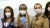 La sprinteuse Rosangela Santos, au centre, montre son certificat de vaccination après avoir reçu une injection du vaccin anti covid Pfizer à Rio de Janeiro, Brésil, le vendredi 14 mai 2021, avant les Jeux Olympiques de Tokyo en juillet. (Photo AP/Silvia Izquierdo)