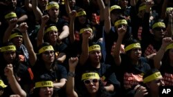 People protesting against human trafficking and slavery raise their fists during a demonstration in Mexico City, Oct. 14, 2017. Dozens of people participated in Mexico City's silent "Walk for Freedom."