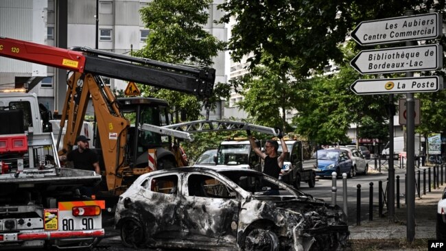 Güneybatı Fransa'nın Bordeaux kentindeki Aubiers mahallesinde yanmış bir araç çekiciye yükleniyor- 30 Haziran 2023