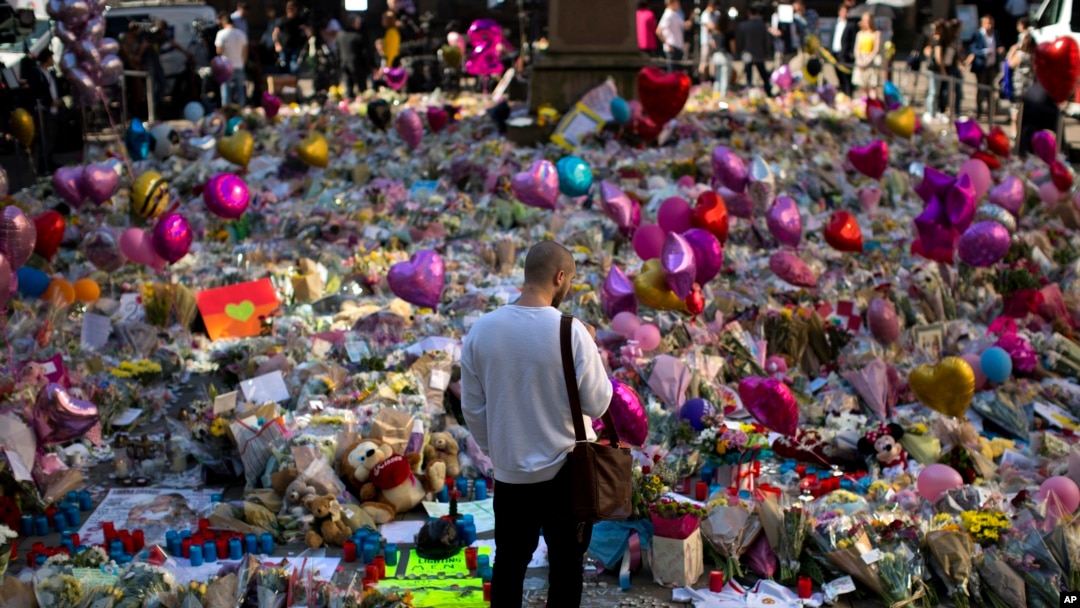A man stands next to flowers for the victims of Monday's bombing at St Ann's Square in central Manchester, England, May 26 2017.