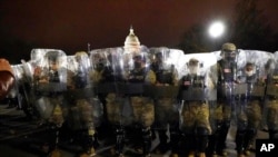 FILE - Members of the District of Columbia National Guard stand outside the Capitol after a day of rioting protesters, Jan. 6, 2021. A report released March 17, 2021, warns that the U.S. is facing one of its most lethal terror threats from within.