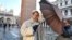 Actor Jude Law holds up an umbrella to block a photographer on the set of Italian director Paolo Sorrentino's TV series "The Young Pope", in St. Mark's Square, Venice, Italy.