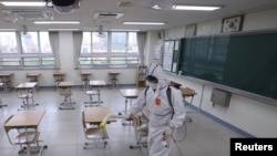 A quarantine worker sprays disinfectant at a high school, following the coronavirus disease outbreak, in Seoul, South Korea, May 11, 2020. 