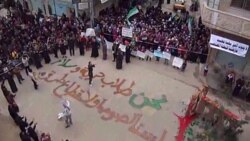 تظاهر کنندگان سوری دز شهر حمص
بر روی زمین نوشته شده است که ما « کسانی هستیم که در پی آزادی و صلح هستیم. ما دزد و قانون شکن نیستیم».