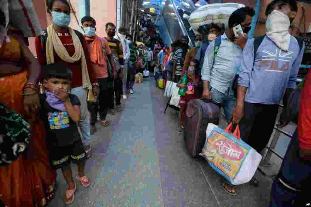 Indian passengers queue up to test for COVID-19 at a facility erected at a railway station to screen people coming from outside the city, in Ahmedabad, India. 