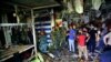 People and security forces gather at the site of a bombing in Wahailat market in Sadr City, Iraq, July 19, 2021.