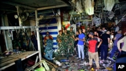 People and security forces gather at the site of a bombing in Wahailat market in Sadr City, Iraq, July 19, 2021.