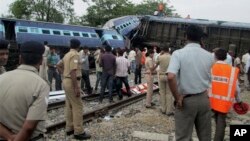 Indian officials and rescuers stand near the wreckage after the Gorakhpur Express passenger train slammed into a parked freight train Chureb, near Basti, Uttar Pradesh state, May 26, 2014.