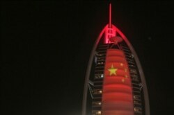 FILE - The Chinese flag is projected onto the Bus Al Arab luxury hotel to celebrate the UAE Chinese Week in Dubai, United Arab Emirates, July 18, 2018.