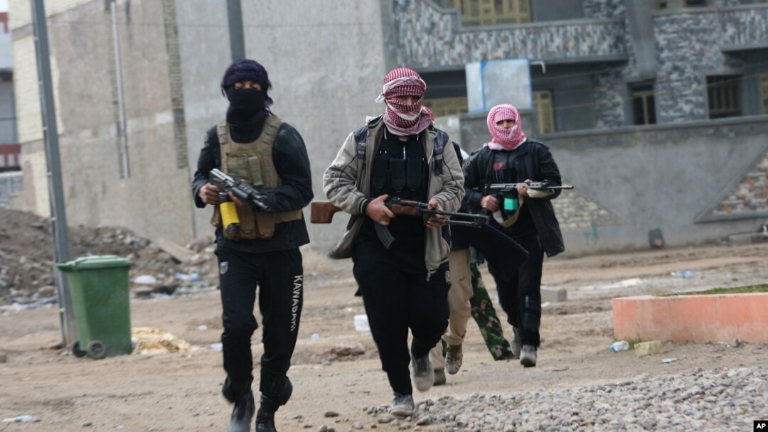 Milisi pro Al-Qaida melakukan patroli jalan-jalan di Fallujah setelah bentrokan dengan pasukan pemerintah Irak (5/1). 