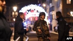 Des policiers discutent avec des militaires dans les rues de Strasbourg, dans l'est de la France, après une fusillade, le 11 décembre 2018.