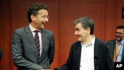 El presidente de la eurozona Jeroen Dijsselbloem estrecha la mano de su colega griego Euclid Tsakalotos, en Bruselas