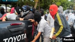 Des partisans du gouvernement se tiennent devant une église à Diriamba, au Nicaragua, le 9 juillet 2018