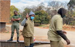 Journalist Hopewell Chin’ono gives a thumbs-up to reporters as he leaves Harare Magistrates Court, Aug. 7, 2020, after launching a third bail application. (Columbus Mavhunga/VOA)