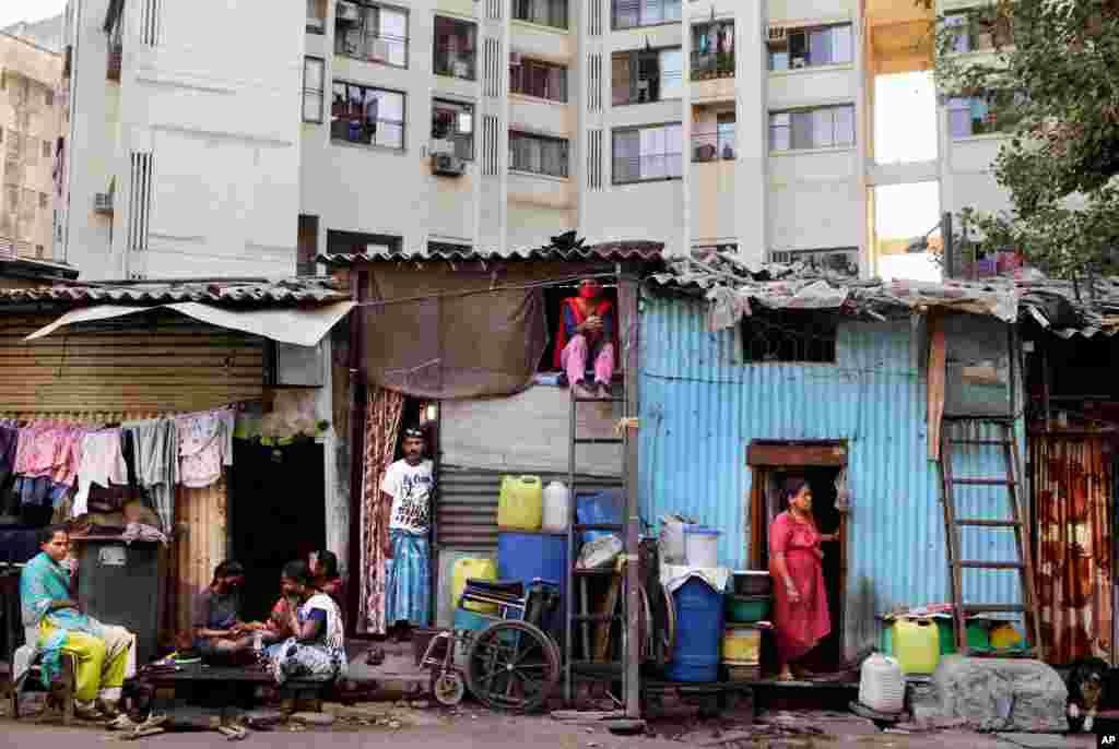 Impoverished Indians rest by their shanties at Dharavi, one of Asia&#39;s largest slums, during lockdown to prevent the spread of the coronavirus in Mumbai, India. 