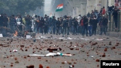 Demonstrators throw stones towards police during a protest against a new citizenship law, in the Seelampur area of Delhi, India, Dec. 17, 2019.