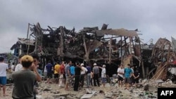 This photo taken and obtained from the Facebook account of Mai So Jar on Sept. 6, 2024 shows people gathering around a destroyed building following an air strike in Namhkham township in Myanmar's northern Shan state. (Photo Courtesy of Facebook user Mai So Jar / AFP) 