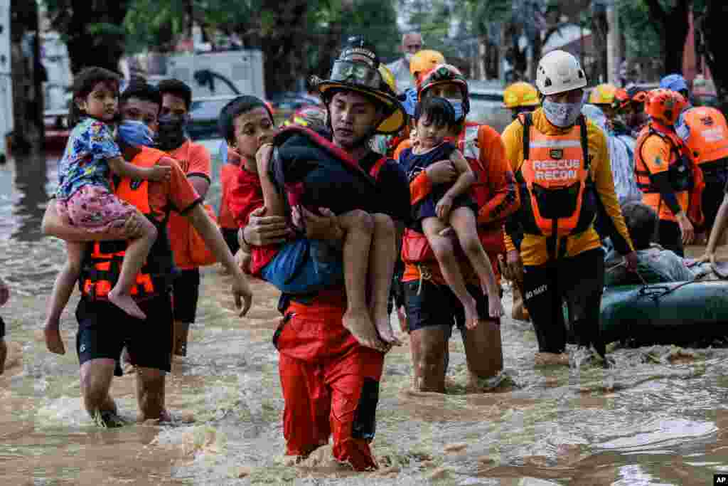 필리핀 마닐라 동부 마리키나시티의 태풍 밤꼬 피해 지역에서 구조대원들이 아이들을 구출하고 있다.