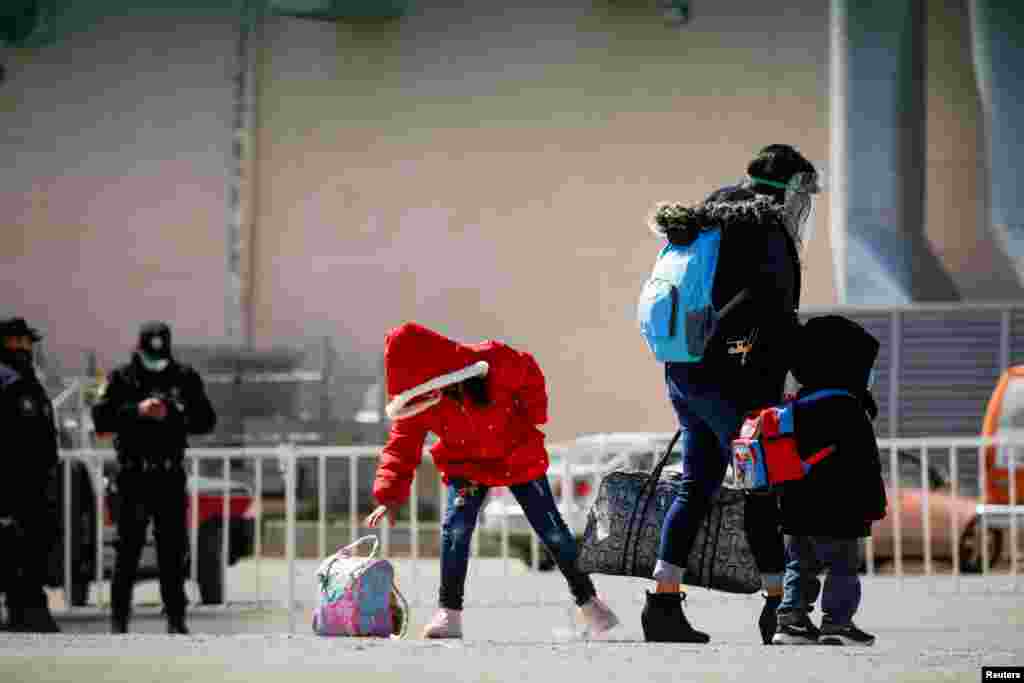 Migrants under the Migrant Protection Protocols (MPP) program wait to take a test for COVID-19 at the Leona Vicario temporary migrant shelter&nbsp;in Ciudad Juarez, Mexico, before being transferred to continue their asylum request in the United States, March 1, 2021.