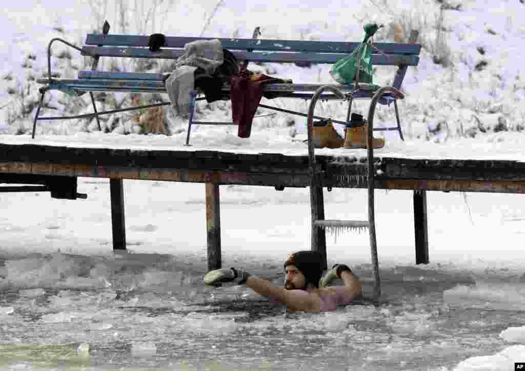 A man bathes in the icy waters of the Dziekanowskie Lake near Lomianki, Poland, in temperatures as low as -12&deg; C (10&deg; F).