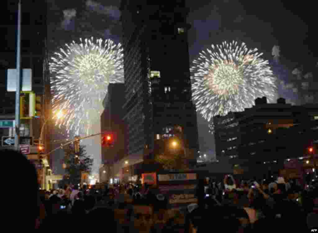 Spectators watch fireworks explode over the Hudson River from 42nd street during Macy's annual 4th of July fireworks show on Monday, July 4, 2011 in New York. (AP Photo/Bill Kostroun)