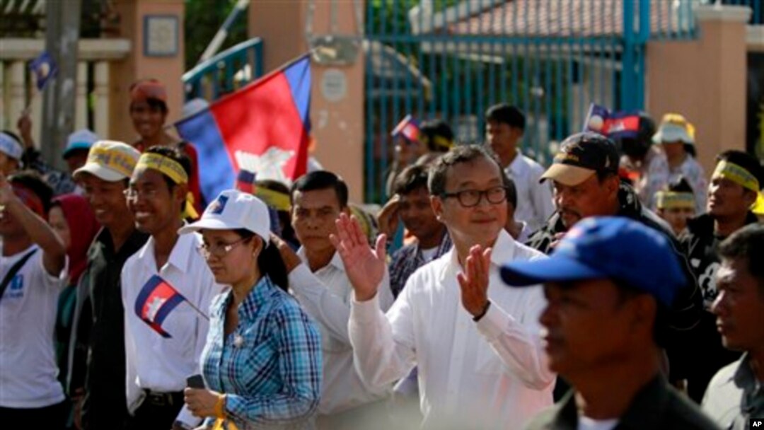 Pemimpin oposisi Kamboja Sam Rainsy (tengah) bertepuk tangan saat memimpin para pendukungnya melakukan aksi unjuk rasa di Phnom Penh, Kamboja (15/9).