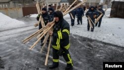 Emergencies Ministry members prepare to repair a building which was damaged during fighting between the Ukrainian army and pro-Russian separatists in the government-held industrial town of Avdiyivka, Ukraine, Feb. 6, 2017. 