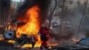 Seorang pekerja medis berjalan di dekat mobil yang terbakar akibat serangan militer Rusia, saat invasi Rusia ke Ukraina berlanjut, di pusat Kyiv, Ukraina 10 Oktober 2022. REUTERS/Gleb Garanich
