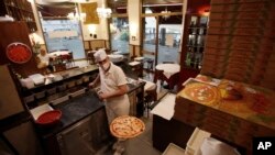 Mimmo makes a pizza at the "La Rotonda di Segrino" restaurant in Milan, Italy, May 19, 2020. 