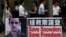 People carrying mobile phones walk past a banner supporting Edward Snowden, a former contractor at the National Security Agency (NSA), at Hong Kong's financial Central district, June 18, 2013. 