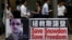 People carrying mobile phones walk past a banner supporting Edward Snowden, a former contractor at the National Security Agency (NSA), at Hong Kong's financial Central district, June 18, 2013. 