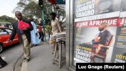 Un homme passe devant des affiches de l'hebdomadaire Jeune Afrique dans le quartier des affaires d'Abidjan, le 21 décembre 2010.