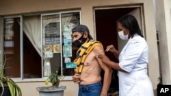 FILE - Andre Luiz da Silva, 70, is injected with a dose of the Pfizer COVID-19 vaccine during a third-dose campaign for elderly residents in long-term care institutions, at a retreat for elderly artists, in Rio de Janeiro, Brazil, Sept. 1, 2021.