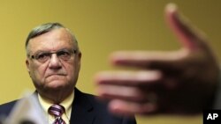 El alguacil de Maricopa Joe Arpaio escucha a uno de sus abogados durante una conferencia de prensa en Phoenix. Arpaio enfrenta acusaciones de discriminación racial.