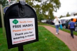 A mailbox containing free masks for pedestrians stands in the center of Tenafly, N.J., Oct. 22, 2020.